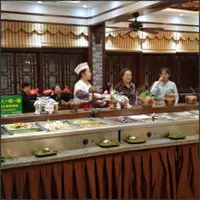 Staff preparing the buffet before opening at Nengren Temple's vegan restaurant.