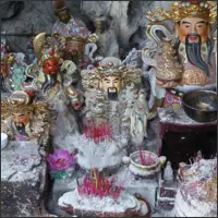 Small shrine with dozens of Buddhist and Daoist figurines inside a limestone cave.