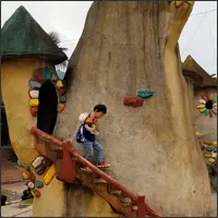 Child descending a staircase beside one of the fantasy-style buildings.